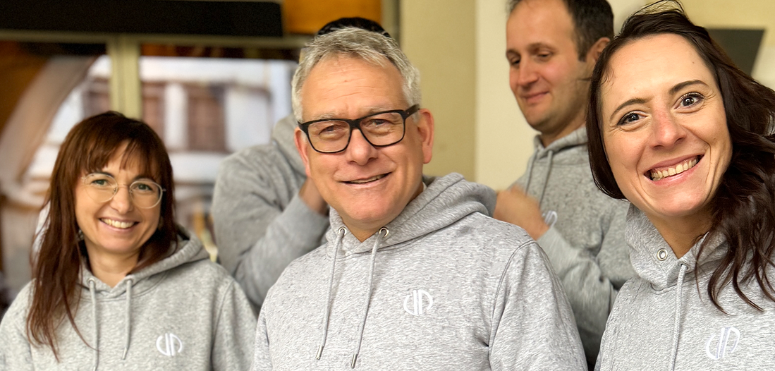 Steuerberater, Vorstände und Prokuristen von Lehleiter + Partner lächeln in die Kamera. Alle haben einen grauen Hoodie mit dem Logo von Lehleiter + Partner an.