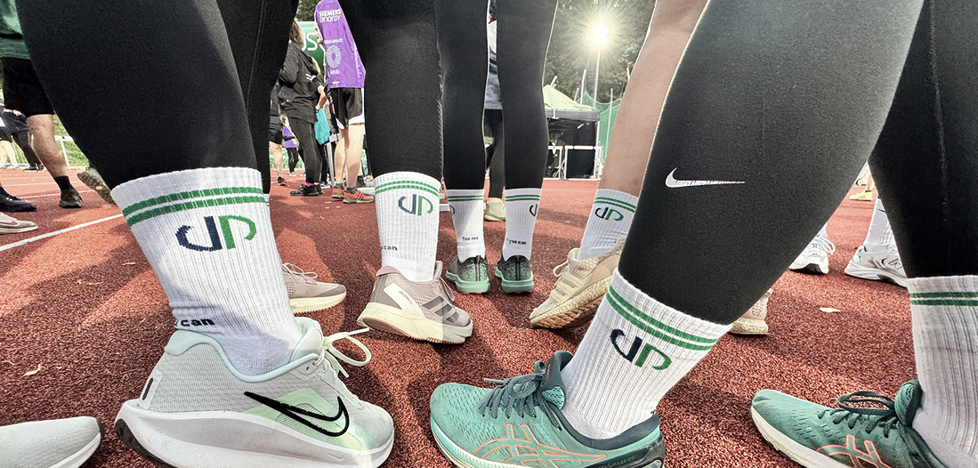 Startklar! Mitarbeiter von Lehleiter + Partner stehen an der Startlinie mit Laufschuhen und Socken von Lehleiter + Partner. Alle sind bereit los zu laufen.