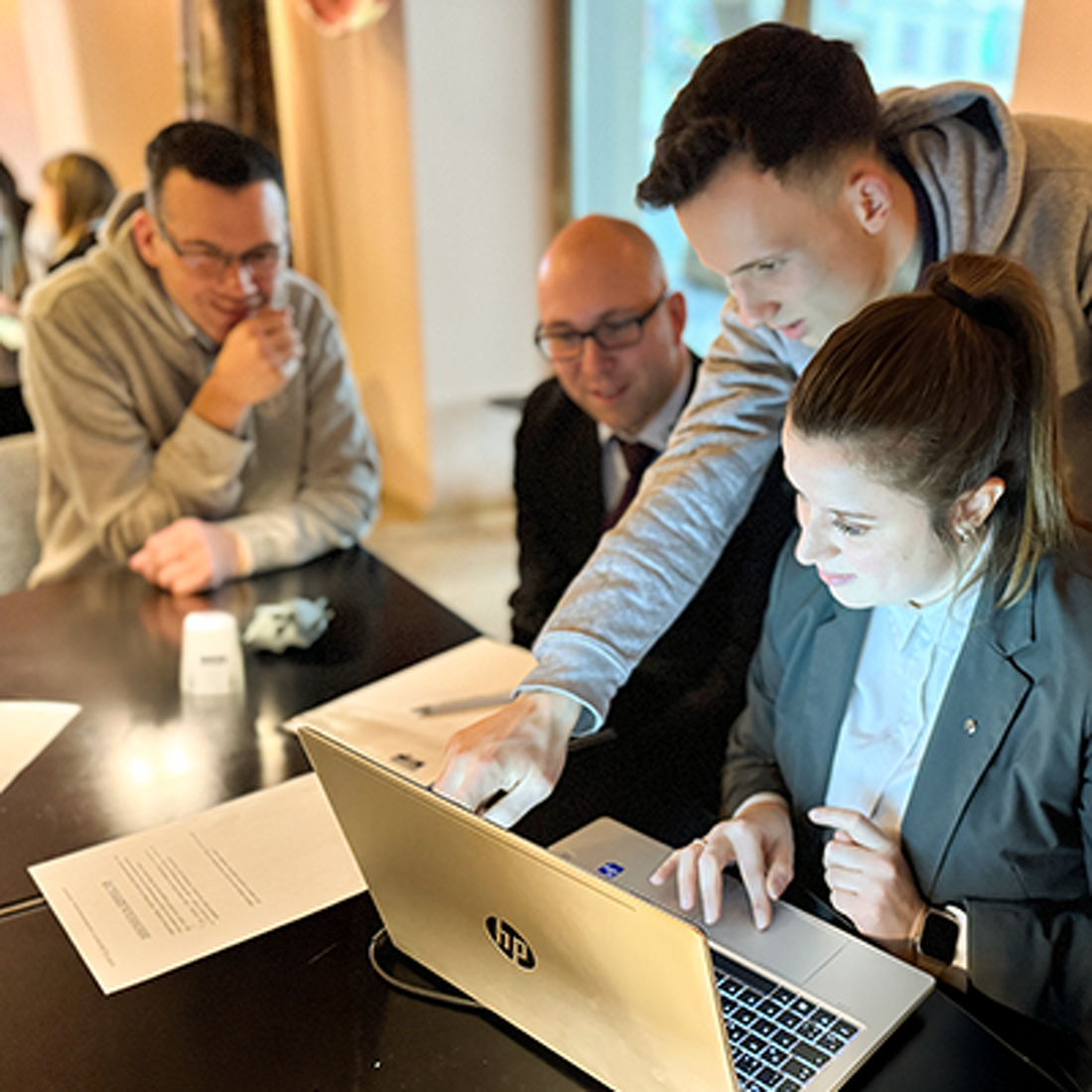 Mitarbeiter von Lehleiter + Partner gruppieren sich um einen Tisch und schauen auf einen Laptop. Sie besprechen sich und bearbeiten die Ergebnisse am PC. Einer zeigt direkt auf den Bildschirm.