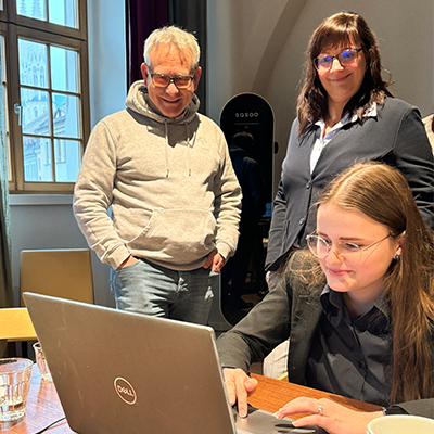 Mitarbeiter von Lehleiter + Partner gruppieren sich um einen Tisch und schauen auf einen Laptop. Sie besprechen sich und bearbeiten die Ergebnisse am PC.